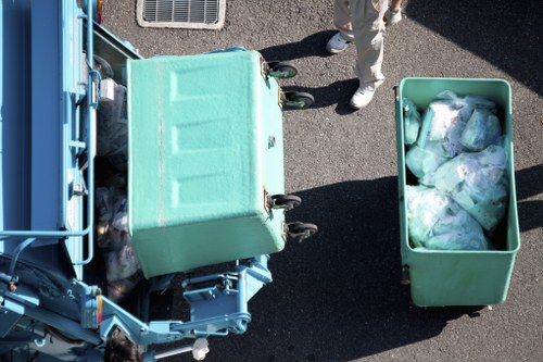 Workers loading waste into a skip in Brompton